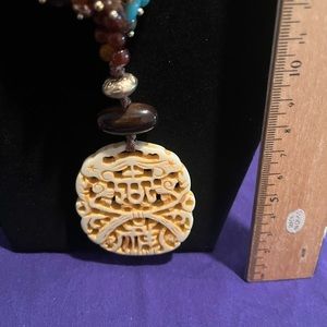 Multi colored beaded necklace with beige pendant